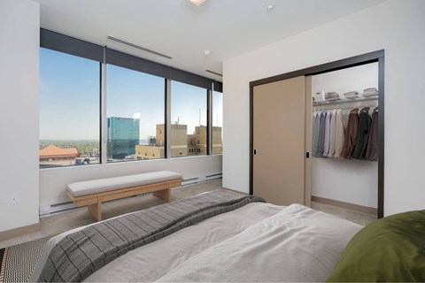 A bedroom with a large bed and a view of the city.