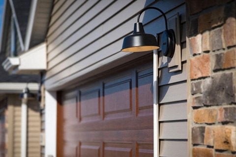 A black lamp is mounted on a house.