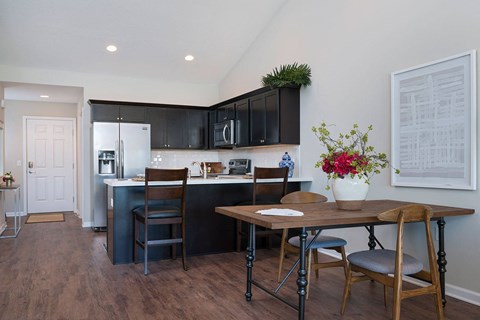 A kitchen with a table and chairs in the middle of the room.