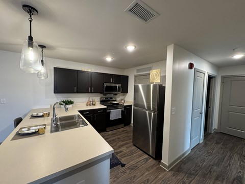 A modern kitchen with a stainless steel refrigerator and a dining table set for two.