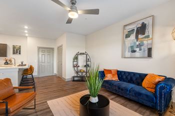 a living room with a blue couch and a ceiling fan at 41 North Senior Living Apartments, Fort Wayne, IN, 46835