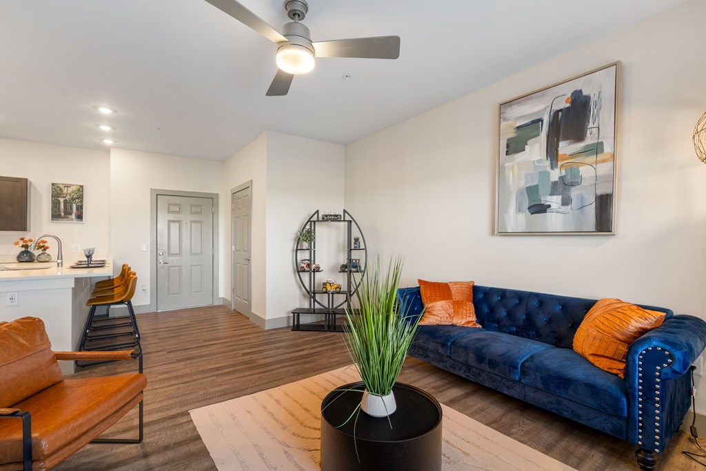 a living room with a blue couch and a ceiling fan at 41 North Apartments, Fort Wayne, IN