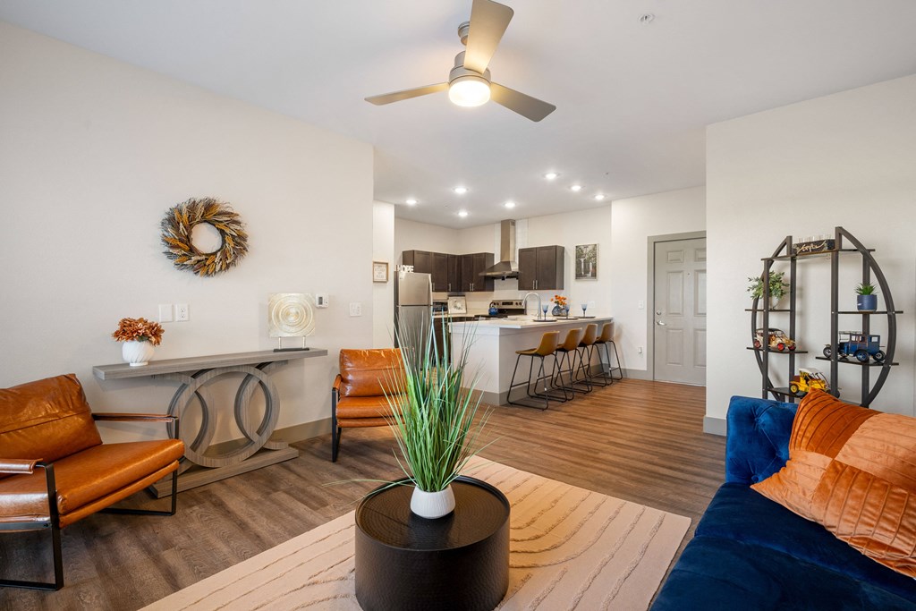 a living room with a couch and a table with a kitchen in the background at 41 North Apartments, Fort Wayne