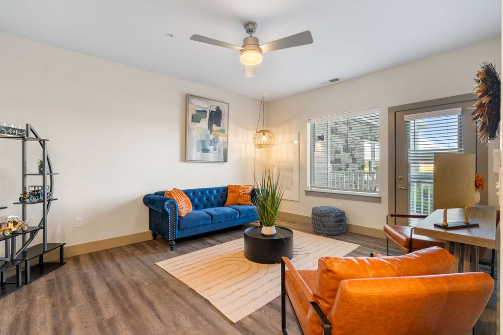 a living room with a blue couch and a ceiling fan at 41 North Apartments, Fort Wayne, IN 46835