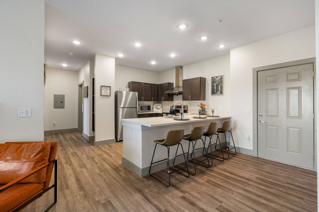 a kitchen and living room with an island and bar stools at 41 North Apartments, Fort Wayne, IN