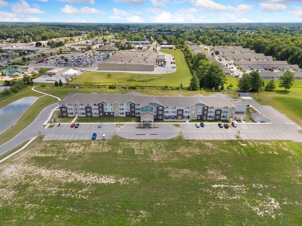 an aerial view of an apartment complex with a parking lot and a lake at 41 North Apartments, Fort Wayne, 46835