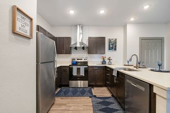 an open kitchen with stainless steel appliances and a refrigerator at 41 North Senior Living Apartments, Indiana