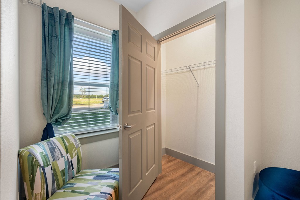 a bedroom with a window and a closet with a door at 41 North Apartments, Fort Wayne, IN