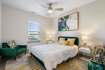 a bedroom with a bed and a chair and a ceiling fan at 41 North Senior Living Apartments, Indiana 46835