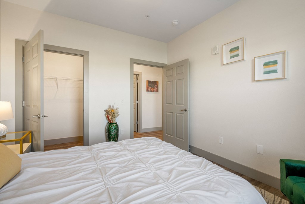a bedroom with a large bed and two doors at 41 North Apartments, Fort Wayne, 46835