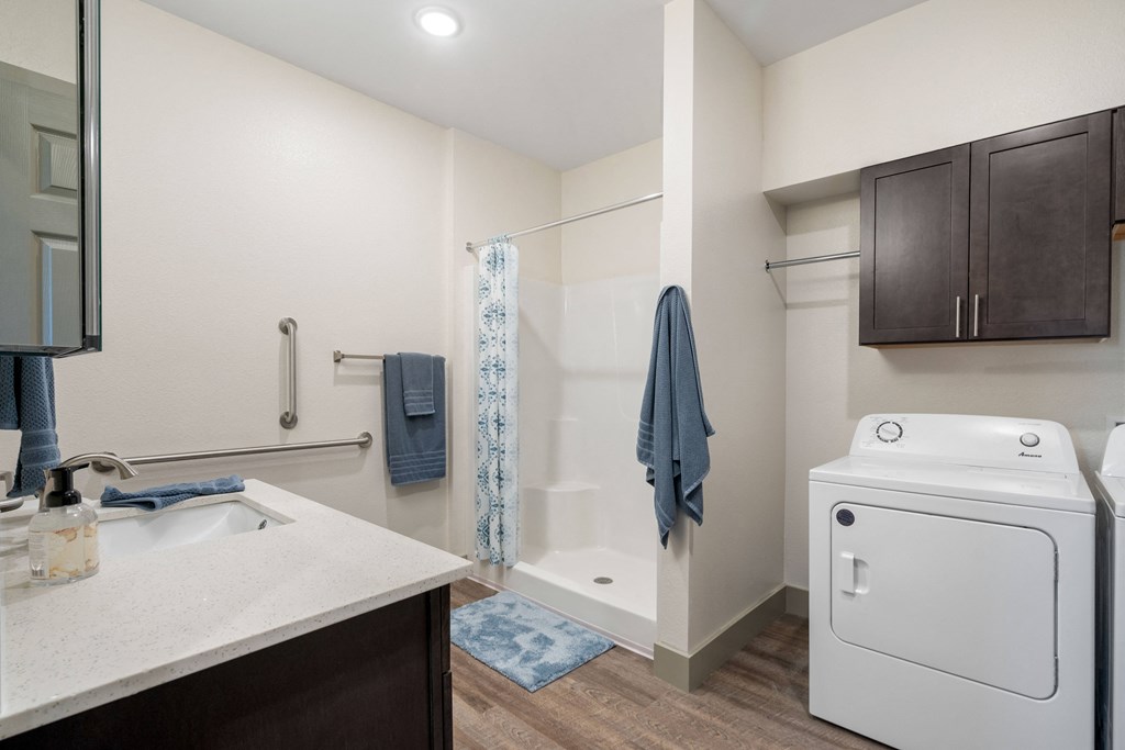 a bathroom with a sink and a shower and a washer and dryer at 41 North Apartments, Indiana