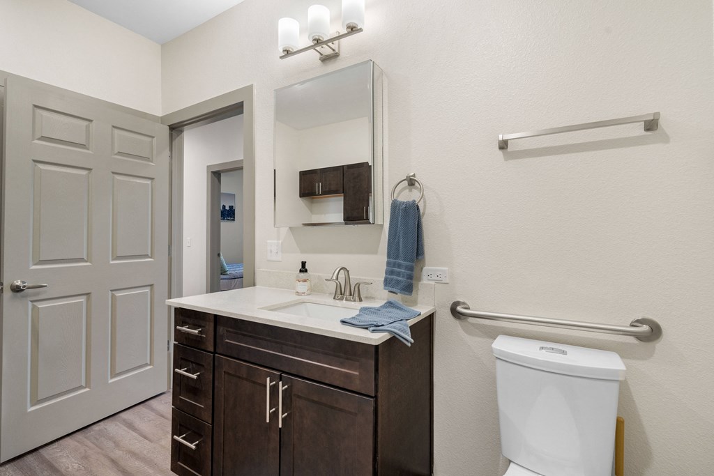 a bathroom with a toilet and a sink and a mirror at 41 North Apartments, Fort Wayne, IN
