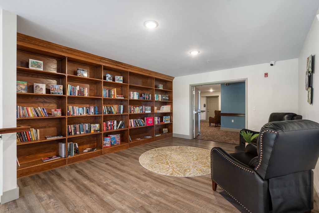 a library with a black leather chair and a book shelf at 41 North Apartments, Indiana, 46835
