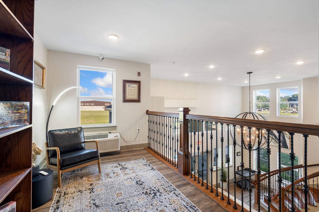 a lounge area with a staircase and a chair and a window at 41 North Apartments, Fort Wayne