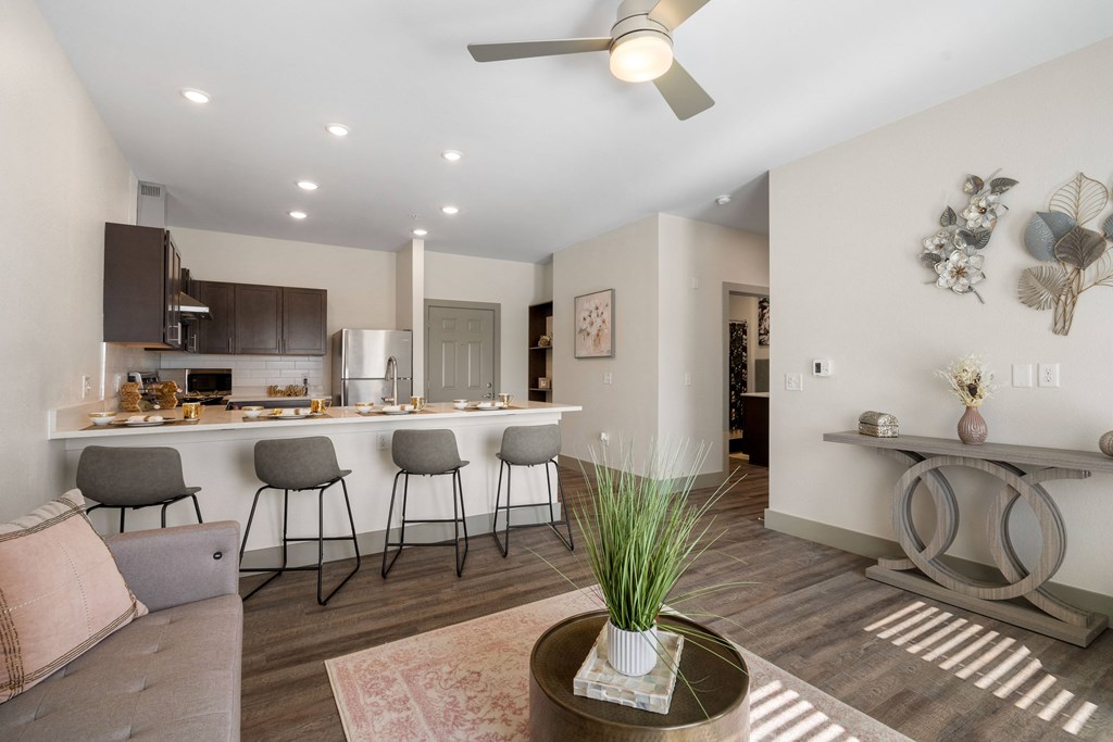 a living room with a kitchen with a bar and a ceiling fan at 41 North Apartments, Fort Wayne, IN