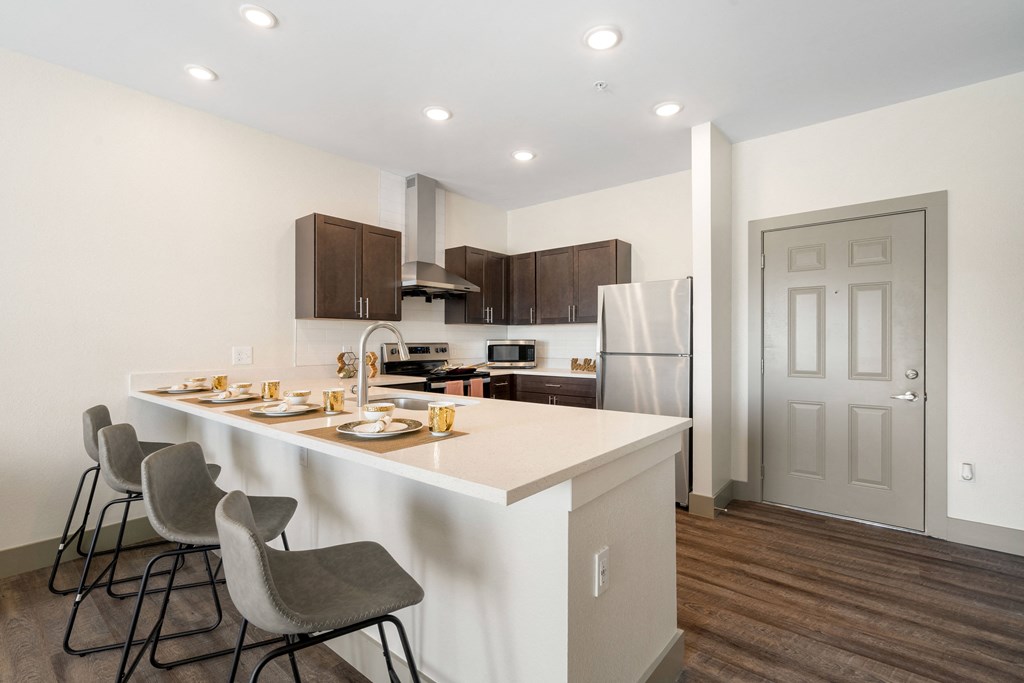 a kitchen with a large island with chairs and a counter top at 41 North Apartments, Fort Wayne Indiana
