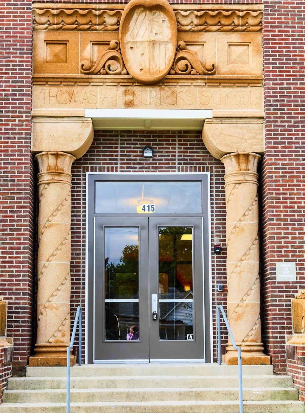 the front door of a brick building with a glass door  at Hendricks Pointe Apts, Shelbyville, IN, 46176