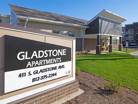 a sign for gladstone apartments in front of a building