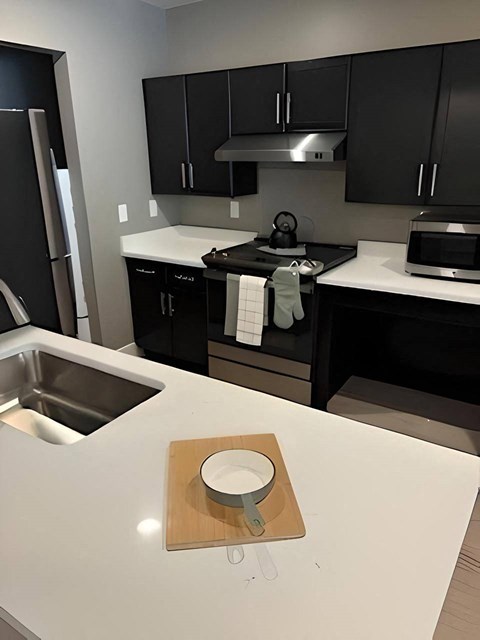 a kitchen with black cabinets and a white counter top