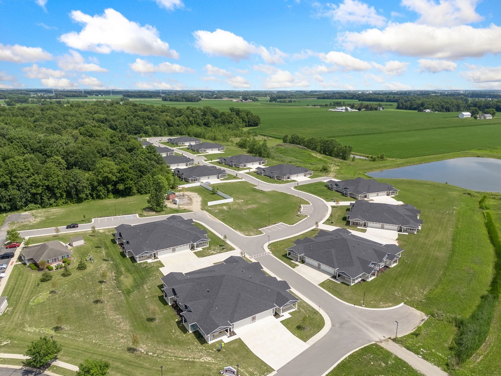 an aerial view of a neighborhood with houses and a pond at Morada at Maysville, Indiana, 46815