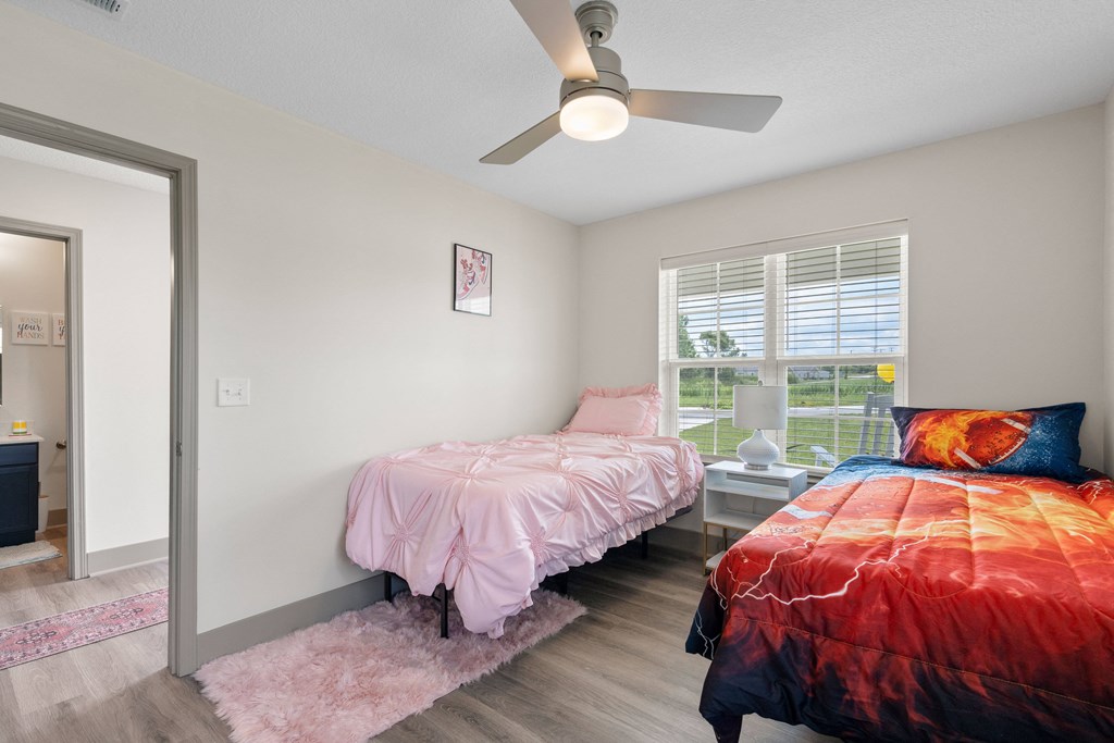 a bedroom with two beds and a ceiling fan at Morada at Maysville, Fort Wayne