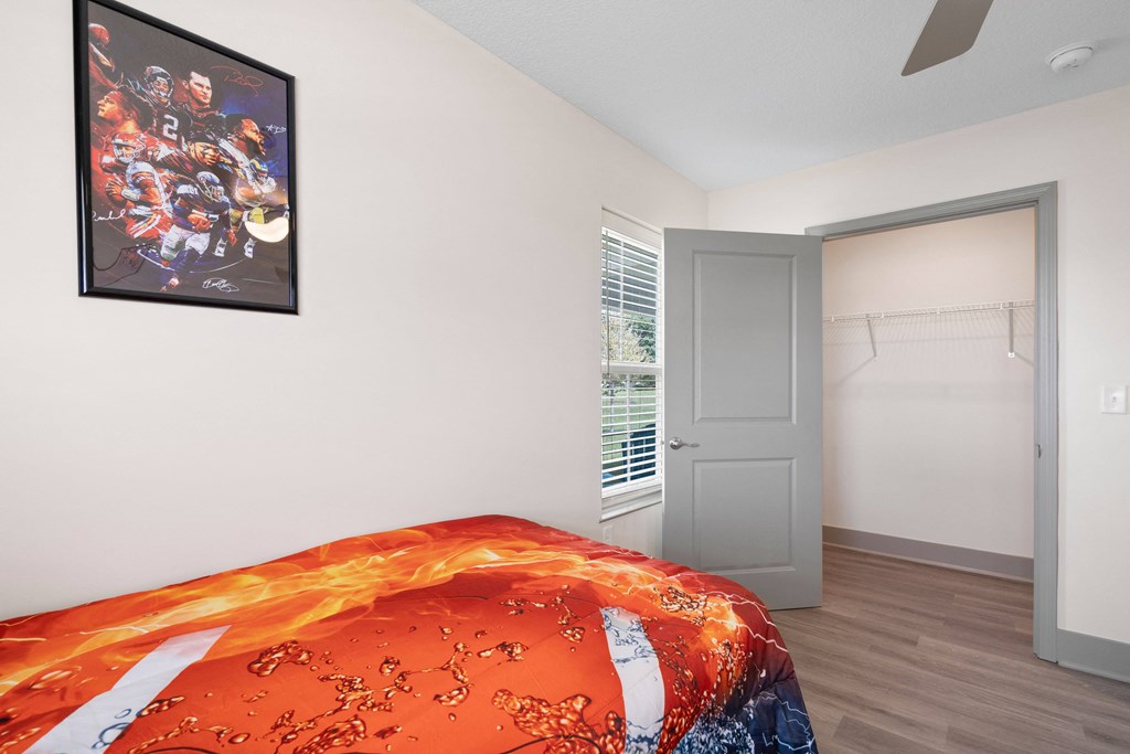 a bedroom with a bed and a door to a closet at Morada at Maysville, Fort Wayne