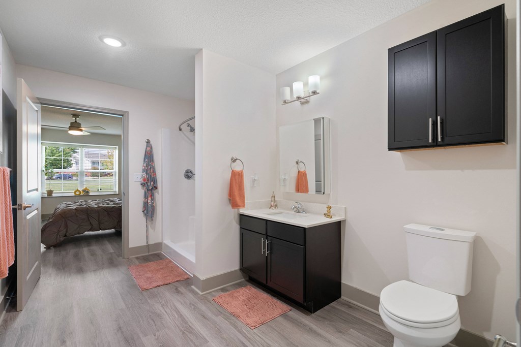 a bathroom with a toilet and a sink and a mirror at Morada at Maysville, Fort Wayne, IN 46815
