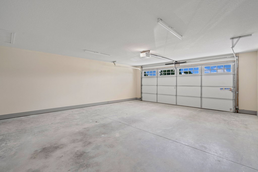 the interior of a garage with white walls and white garage doors at Morada at Maysville, Fort Wayne, IN 46815