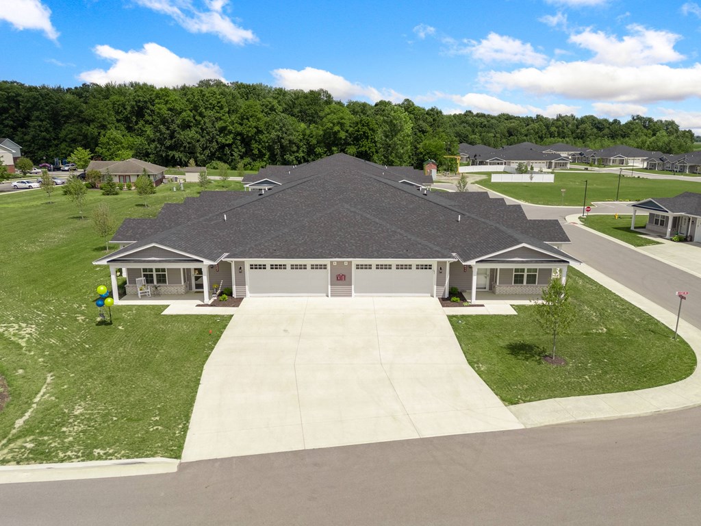 a house with a driveway in front of a grass yard at Morada at Maysville, Fort Wayne Indiana