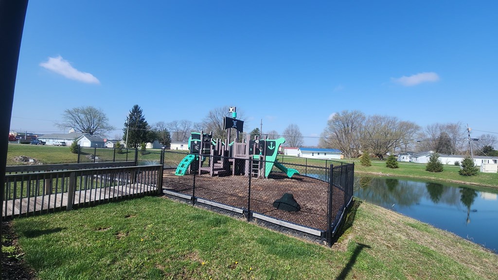 A playground with a green slide and a play structure.