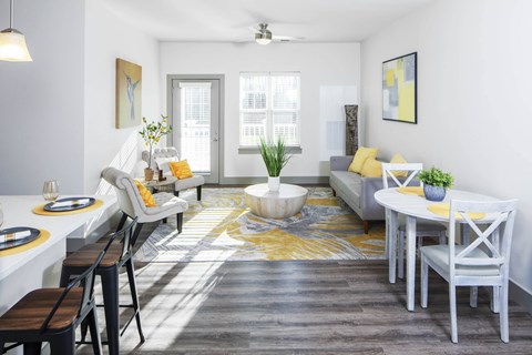 a living room with a dining room table and chairs