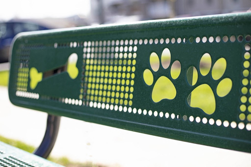 a green bench with yellow paw prints on it  at Gladstone Apartments, Columbus, Indiana