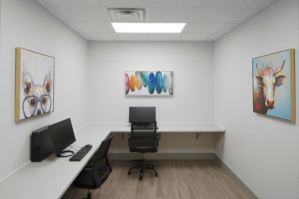 a room with computers and paintings on the wall