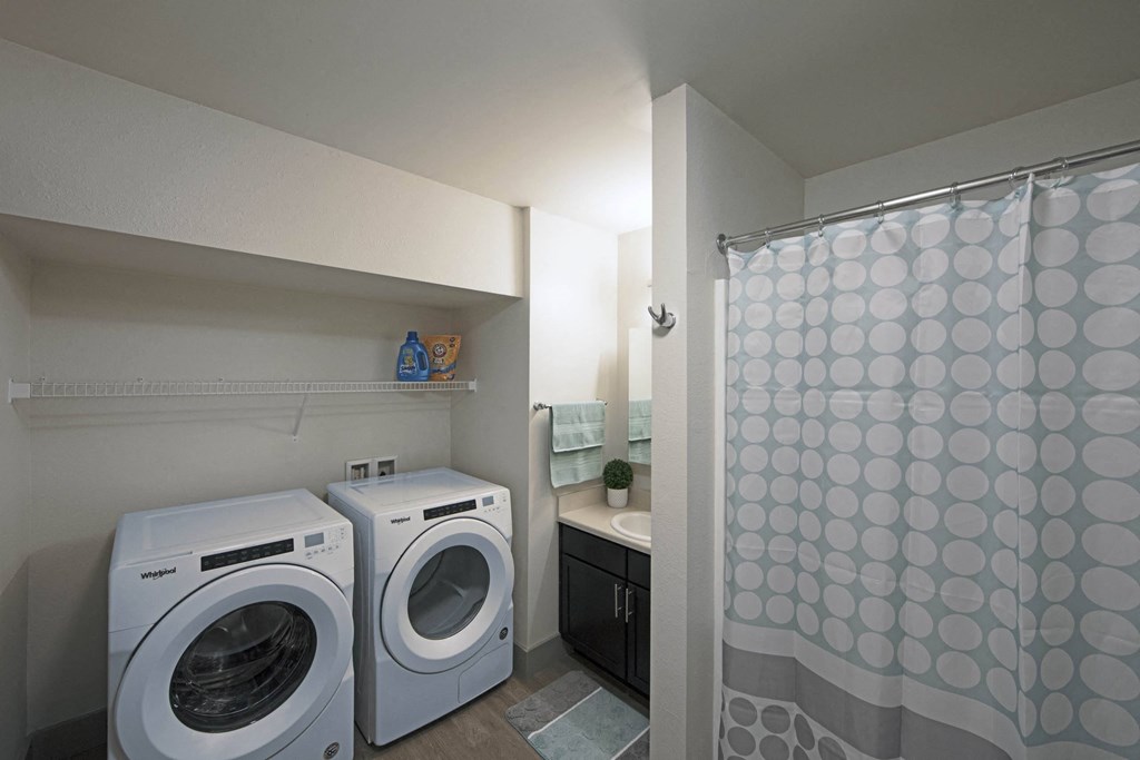 a washer and dryer in a laundry room with a shower
