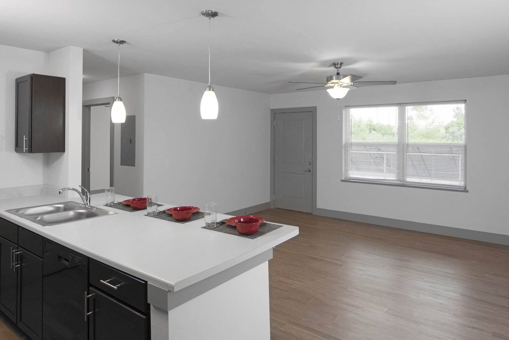 an empty kitchen and living room with a white counter top