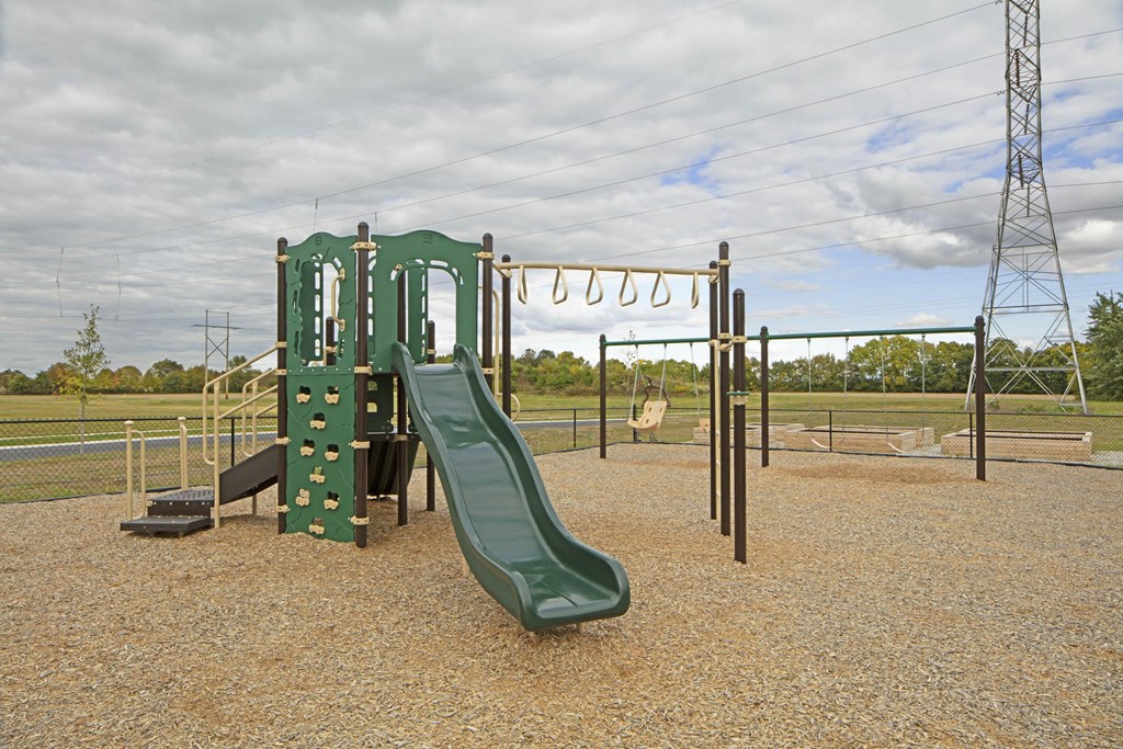 a playground with a slide and climbing equipment in a park