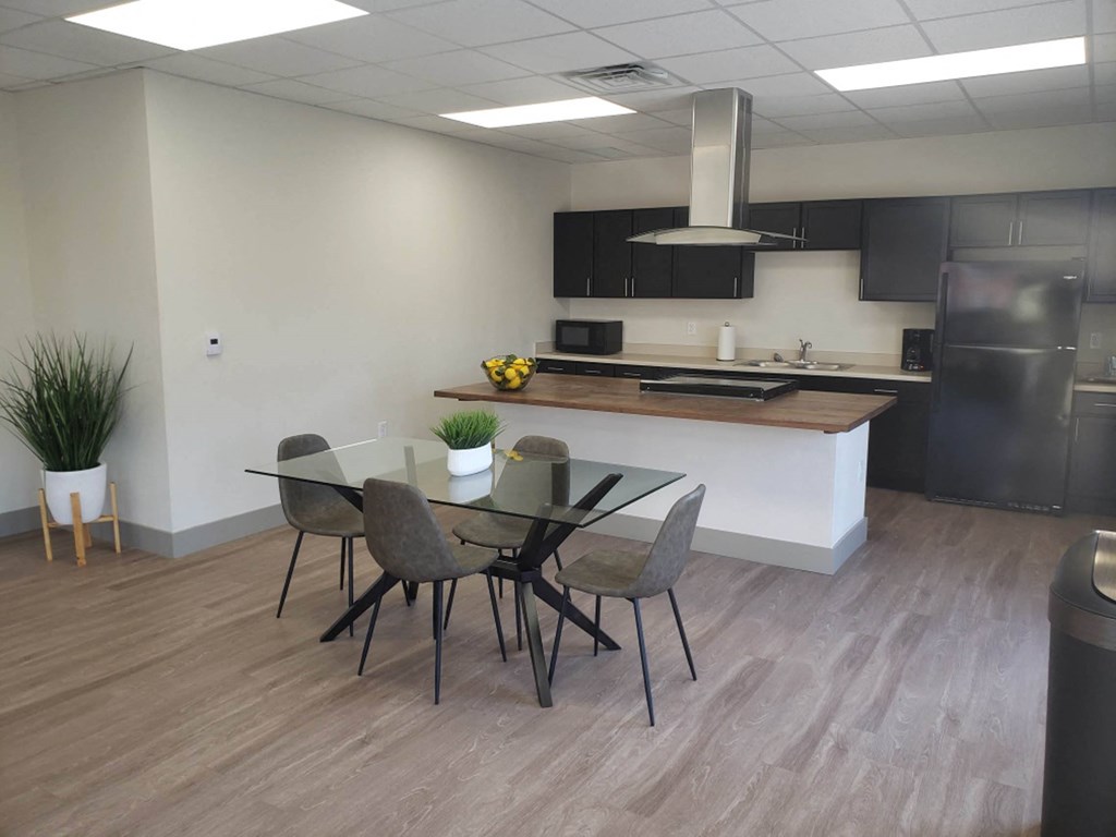 a dining room and kitchen in an office space with a table and chairs