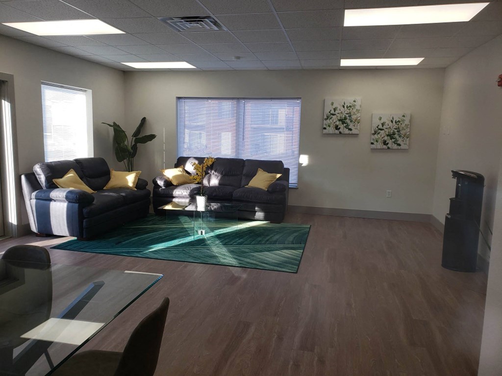 an empty living room with couches and a glass table