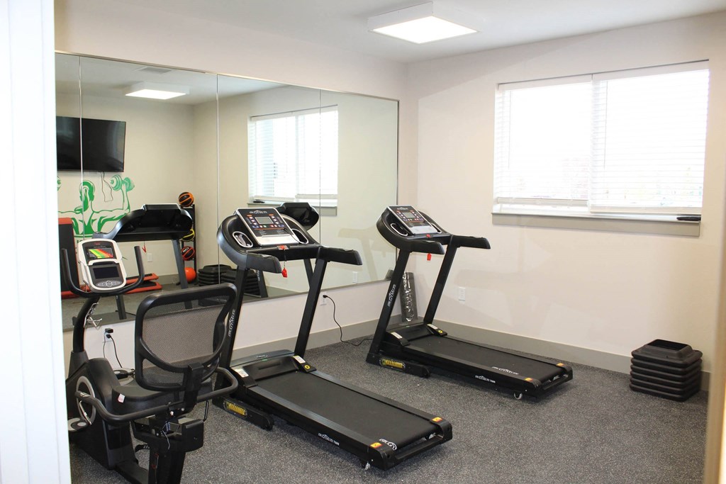 a workout room with exercise equipment in front of a mirror  at Haven Homes Apartments, LP, Indiana