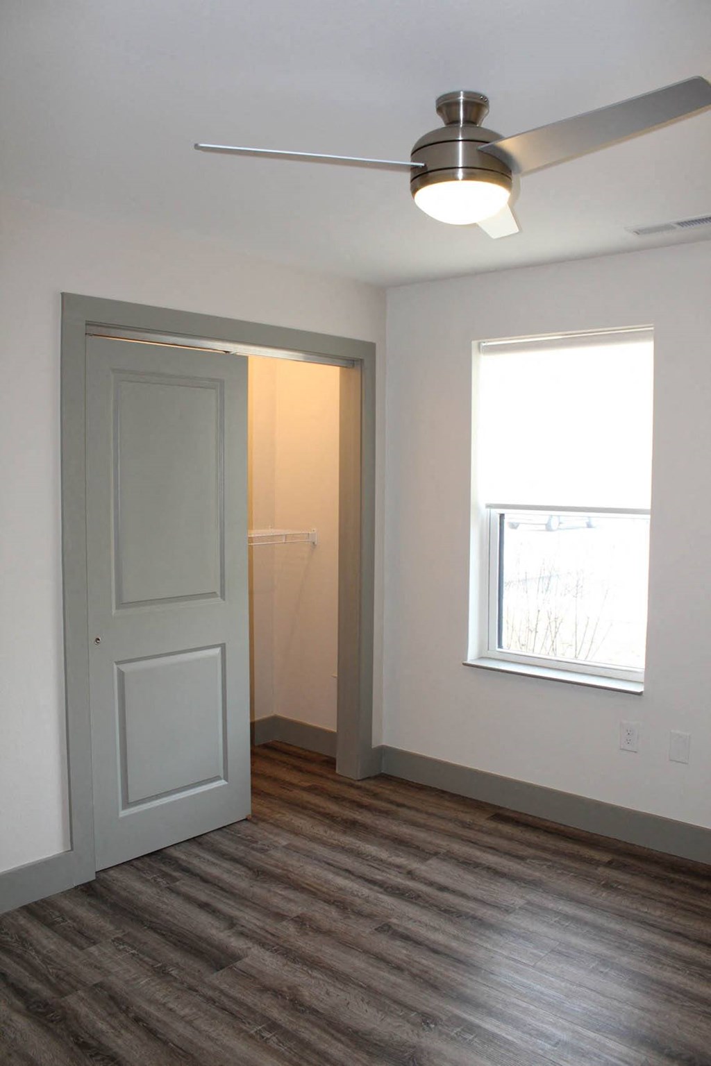 an empty room with a white door and a window  at Haven Homes Apartments, LP, Plainfield, IN, 46168