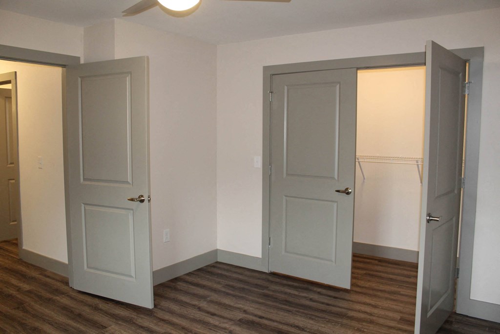 an empty room with three doors and a wood floor  at Haven Homes Apartments, LP, Plainfield, 46168