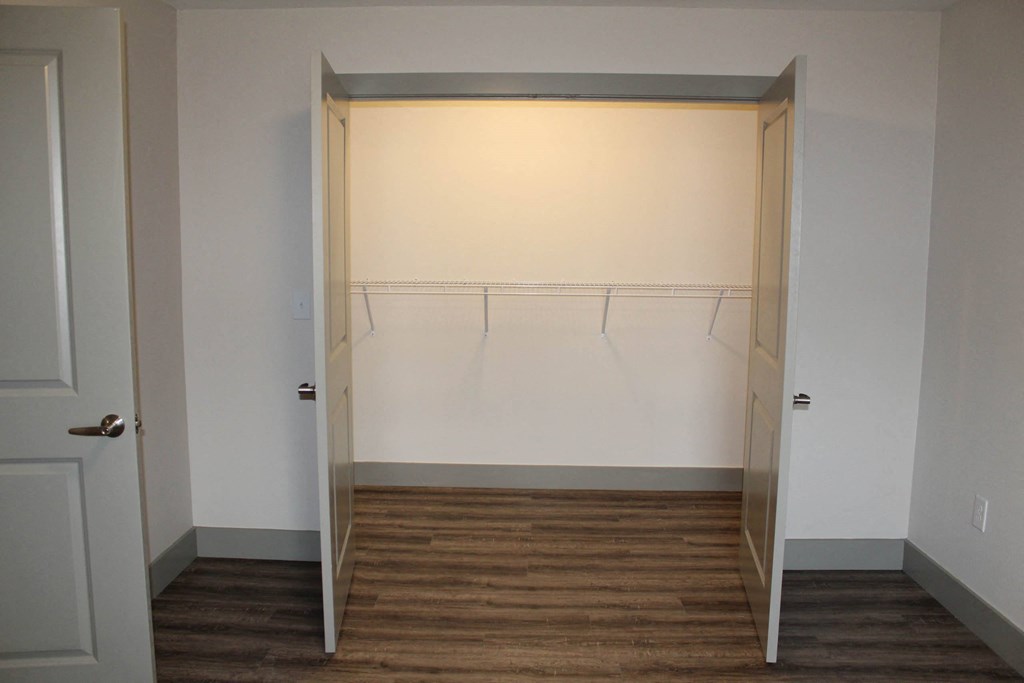 an empty closet with white walls and a wood floor  at Haven Homes Apartments, LP, Plainfield, IN, 46168