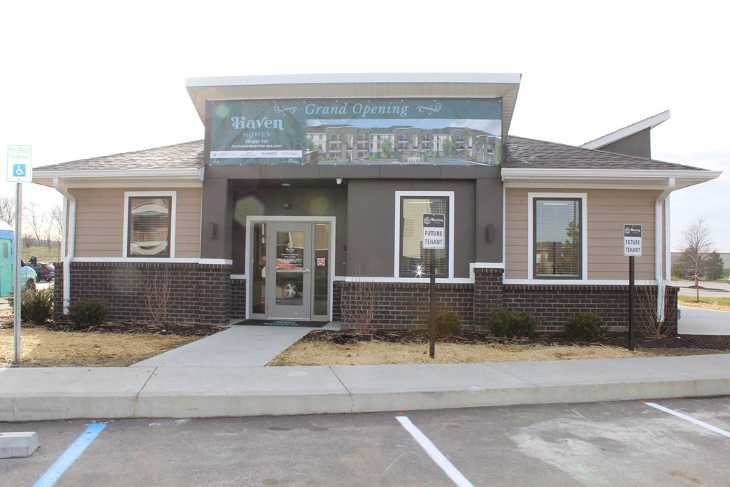 the front of a brown building with a sidewalk and a parking lot  at Haven Homes Apartments, LP, Indiana, 46168