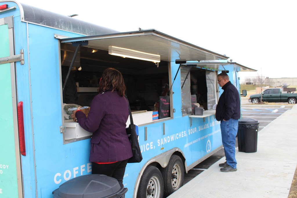 a man and woman ordering food from a food truck  at Haven Homes Apartments, LP, Indiana