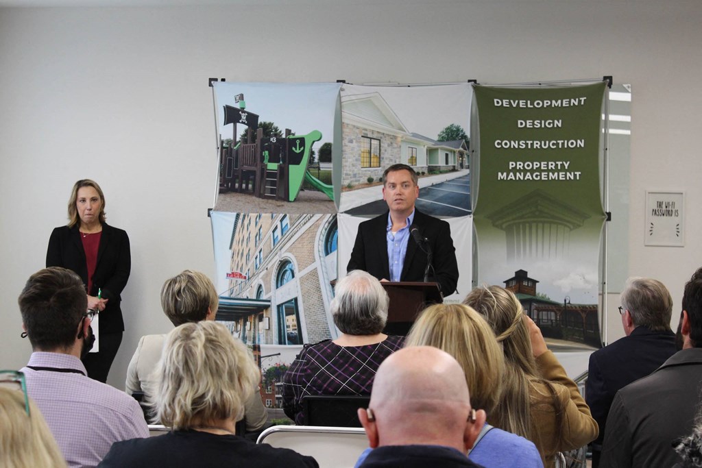 a man and a woman standing at a podium in front of a crowd of people  at Haven Homes Apartments, LP, Plainfield, IN, 46168