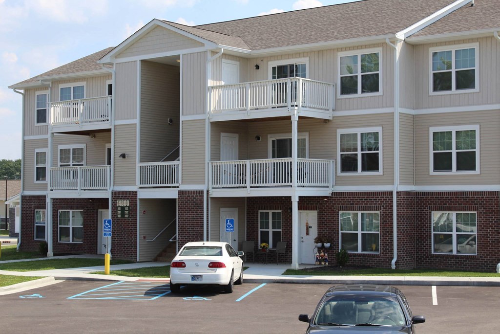 an apartment building with cars parked in front of it at Salem Place Apartments, Daleville, IN, 47334