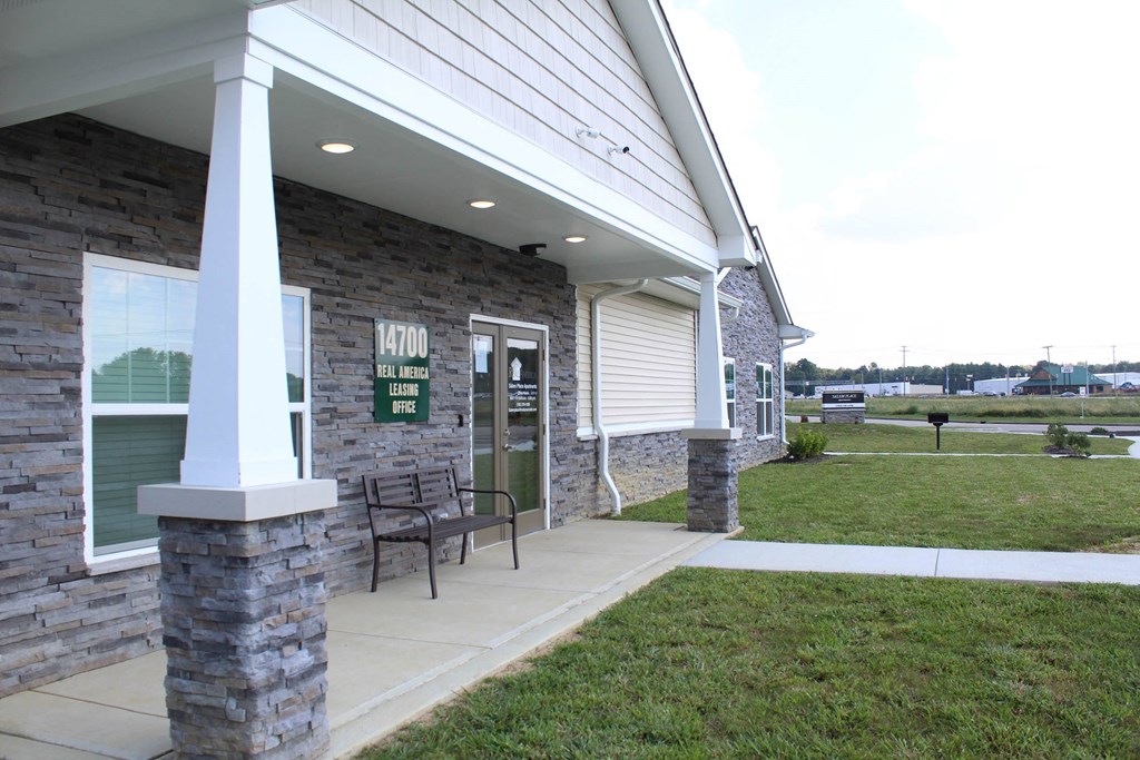 the front porch of the building has a bench and grass at Salem Place Apartments, Daleville, Indiana
