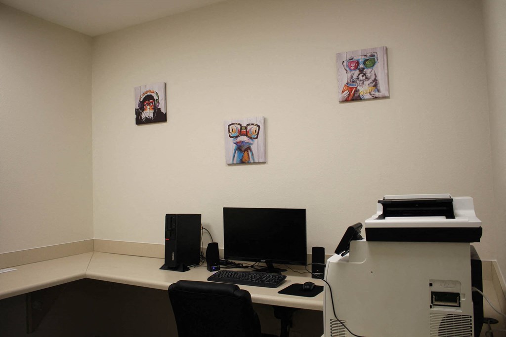 a desk with a computer and a printer in a room with pictures on the wall at Salem Place Apartments, Indiana