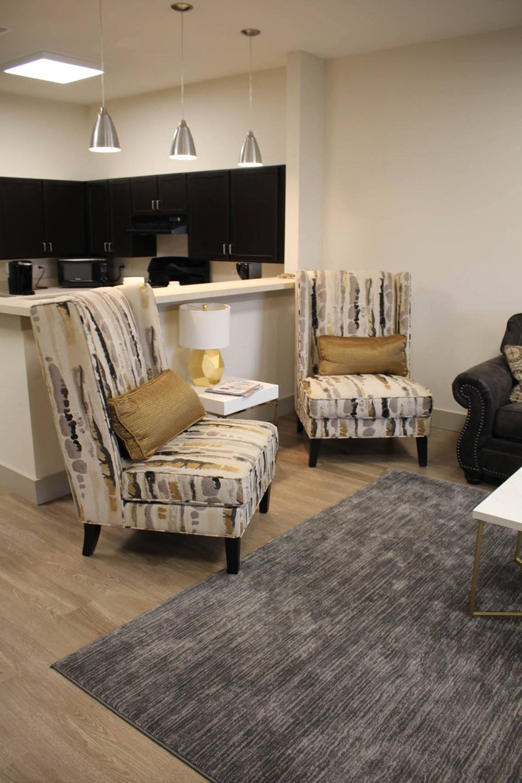 a living room with two chairs and a table at Salem Place Apartments, Daleville, Indiana