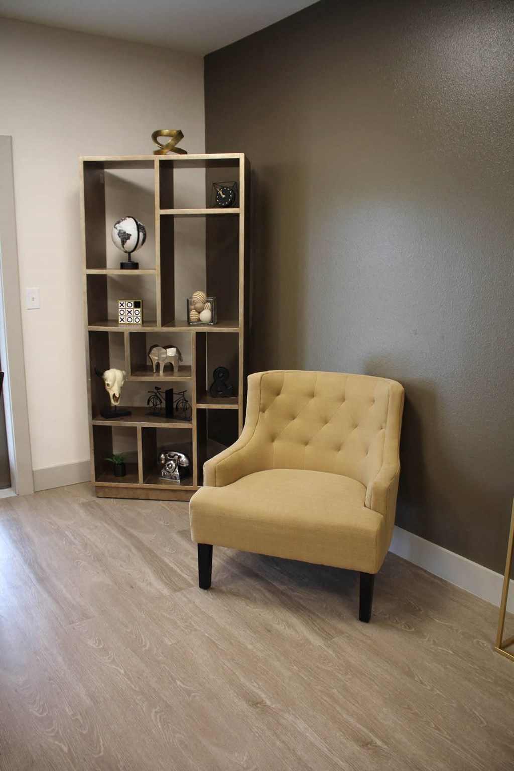 a yellow chair in a room with a bookshelf at Salem Place Apartments, Daleville, 47334